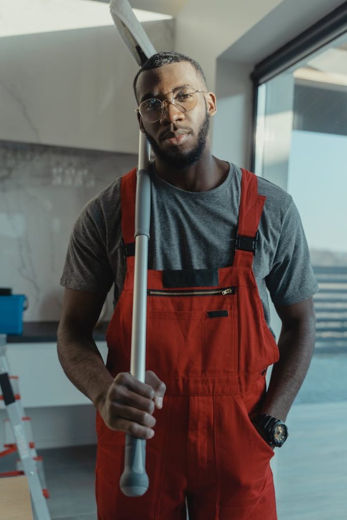 Crafting Captivating Headlines: Your awesome post title goes here Confident male cleaner posing with cleaning tool in modern interior, showcasing professionalism.